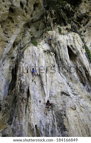 RAILAY, KRABI, THAILAND - MARCH 27: Rock climber ascends one of the popular climbing routes on March 27, 2014, at Railay Beach, Krabi, Thailand. Railay beach is a popular rock climbing location.