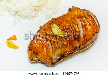 A tasty cooked goose\'s magret with orange, garlic and rice