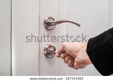 Opening or closing a safety lock on the toilet door
