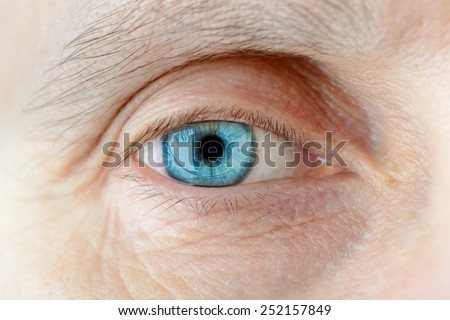 Macro of a hard contact lens on woman\'s blue eye