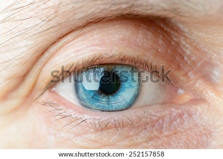 Macro of a hard contact lens on woman\'s blue eye