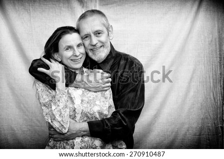 Happy mature man and woman smiling for S. Valentine\'s day or anniversary and embracing each other. Black and white photo.
