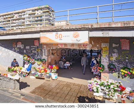Kiev/Ukraine - April 09, 2015 - Women selling flowers and plastic shoes close to the underpass under the sun in Kiev the capital of Ukraine