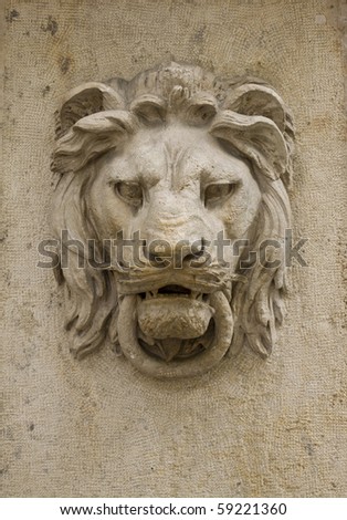 Architectural detail of a lion\'s head on the wall of a building