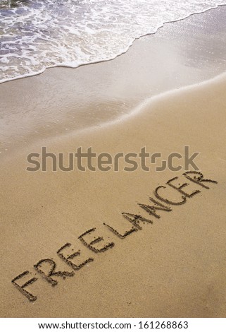 Word FREELANCER written in sand, on a beautiful beach, Freelance concept