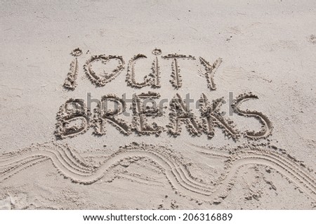 I Love City Breaks message written on sand, vacation concept