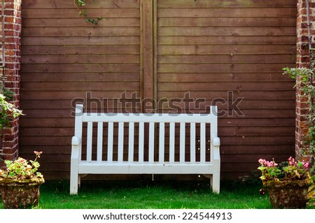 White Wooden garden bench in English garden, retro color filter applied
