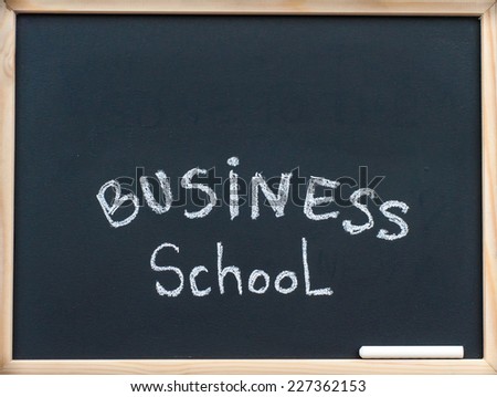 Business school message written with white chalk on wooden frame blackboard, business learning concept