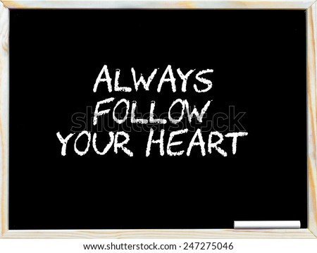 Always follow your heart, vintage chalk text on blackboard, white piece of chalk in the corner, Lifestyle conceptual image