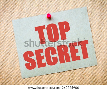 Recycled paper note pinned on cork board. Top Secret Message. Concept Image