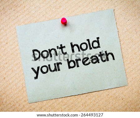 Don\'t hold your breath Message. Recycled paper note pinned on cork board. Concept Image