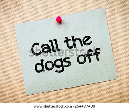 Call the dogs off Message. Recycled paper note pinned on cork board. Concept Image
