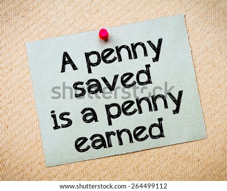 A penny saved is a penny earned Message. Recycled paper note pinned on cork board. Concept Image