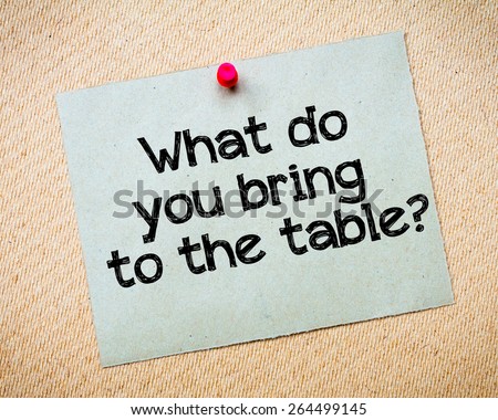 What do you bring to the table? Message. Recycled paper note pinned on cork board. Concept Image