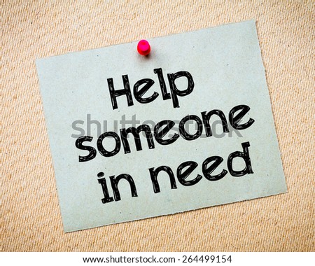 Help someone in need Message. Recycled paper note pinned on cork board. Concept Image