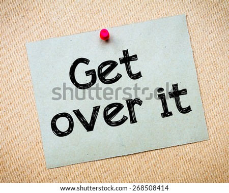 Get Over It Message. Recycled paper note pinned on cork board. Concept Image