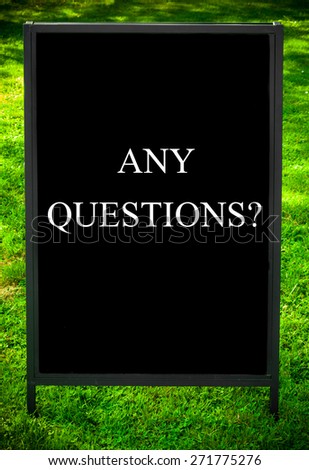 ANY QUESTIONS?  message on sidewalk blackboard sign against green grass background. Copy Space available. Concept image