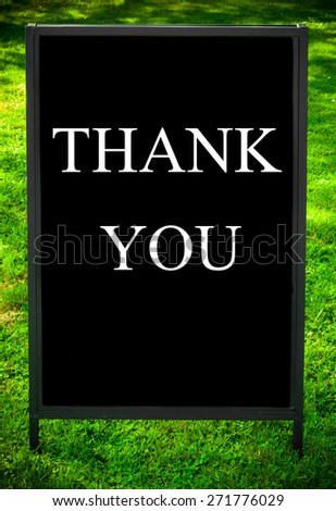 THANK YOU message on sidewalk blackboard sign against green grass background. Copy Space available. Concept image