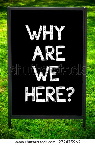 WHY ARE WE HERE?  message on sidewalk blackboard sign against green grass background. Copy Space available. Concept image