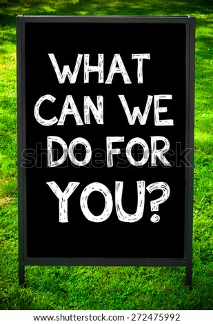 WHAT CAN WE DO FOR YOU?  message on sidewalk blackboard sign against green grass background. Copy Space available. Concept image