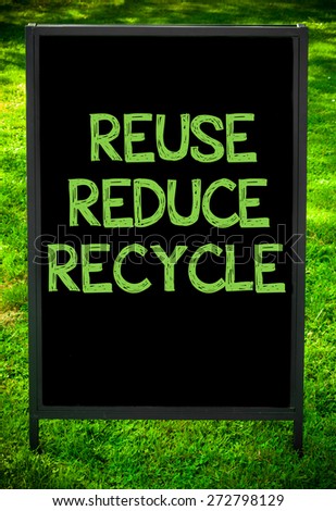 REUSE, REDUCE, RECYCLE  message on sidewalk blackboard sign against green grass background. Copy Space available. Concept image