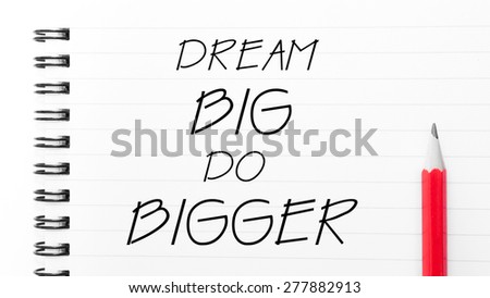 Dream Big Do Bigger Text written on notebook page, red pencil on the right. Motivational Concept image