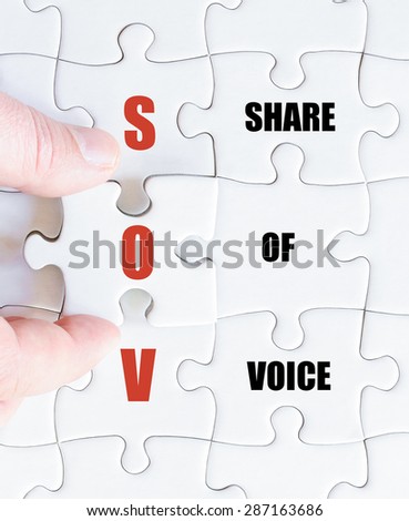 Hand of a business man completing the puzzle with the last missing piece.Concept image of Business Acronym SOV as Share Of Voice