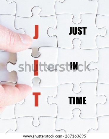 Hand of a business man completing the puzzle with the last missing piece.Concept image of Business Acronym JIT as Just In Time