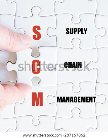 Hand of a business man completing the puzzle with the last missing piece.Concept image of Business Acronym SCM as Supply Chain Management