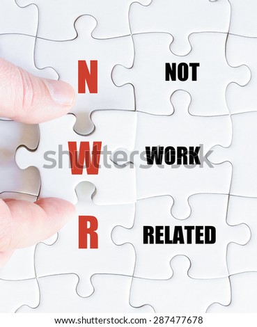 Hand of a business man completing the puzzle with the last missing piece.Concept image of Business Acronym NWR as Not Work Related