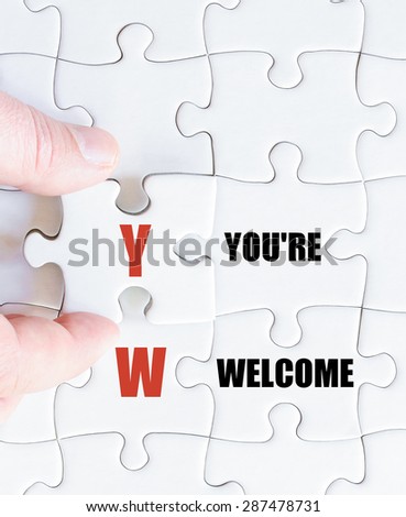 Hand of a business man completing the puzzle with the last missing piece.Concept image of Business Acronym YW as You Are Welcome