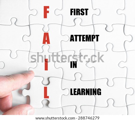 Hand of a business man completing the puzzle with the last missing piece.Concept image of Business Acronym FAIL as First Attempt In Learning
