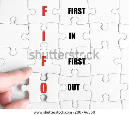 Hand of a business man completing the puzzle with the last missing piece.Concept image of Business Acronym FIFO as First In First Out