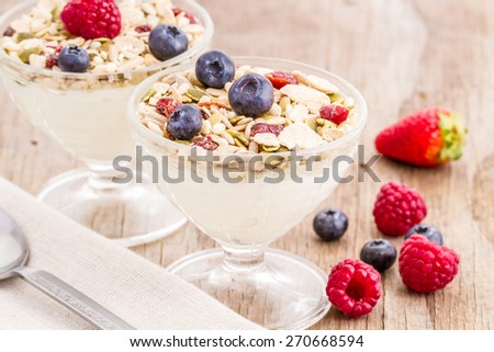 healthy homemade granola or muesli with toasted oats, dried cherry, cranberry, figs, raisin, hazelnuts, cashew, walnuts, yogurt and fresh fruits