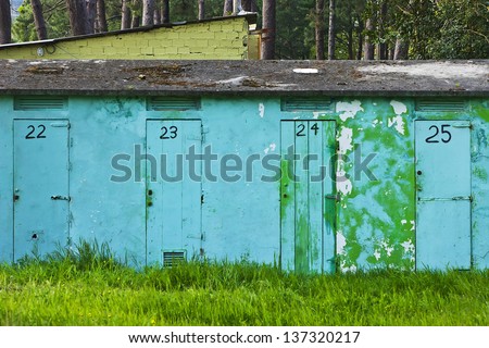 blue facade with doors numbered and forest in the background