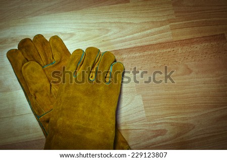 Pair of work gloves on wooden surface
