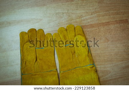 Pair of work gloves on wooden surface