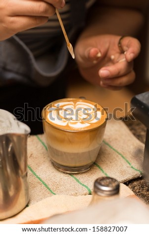 close up making art of coffee with bamboo stick