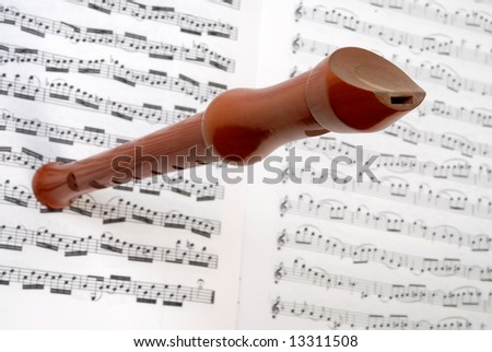 Flute in wood on white  music sheet