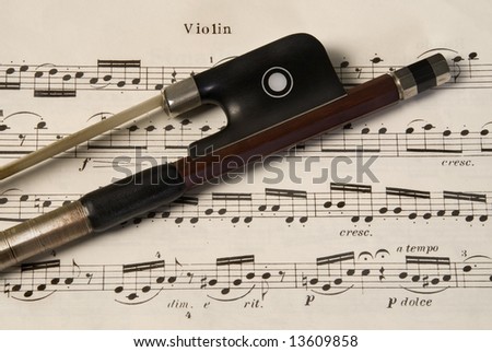 violin bow on music chart sheet