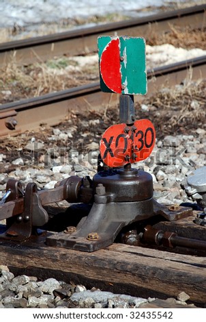 old and weathered railway - red and green device switch rail track