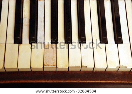 very old wooden piano with ivory keys broken and scratched
