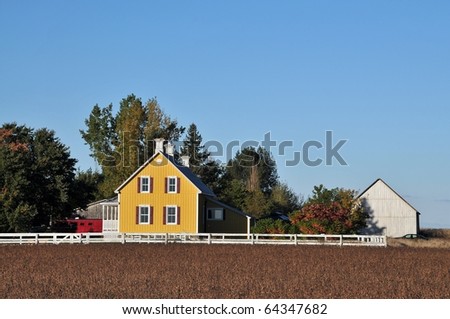 Yellow house in the soy field at fall