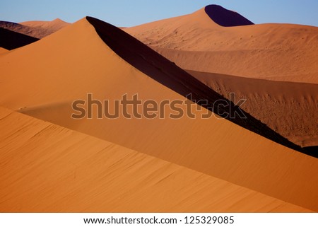 Orange sand dunes with strong shadows in Soussusvlei - Namib Desert, Namibia