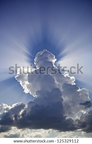 Angelic / antrophomorphic cloud in the sky with sun-rays casting a shadow in the water vapor