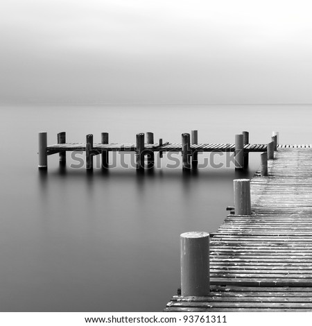 Calm scene in black and white with detail of wooden jetty