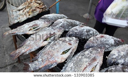 Salted fish on a charcoal grill.