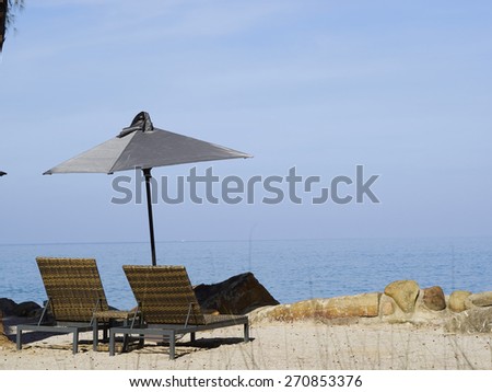Summer, Travel, Vacation and Holiday concept - Beach chairs and umbrella on wooden desk against blue sky in Moo Koh Surin,Thailand