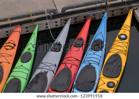 Several colorful kayaks tied at dock in Alaska
