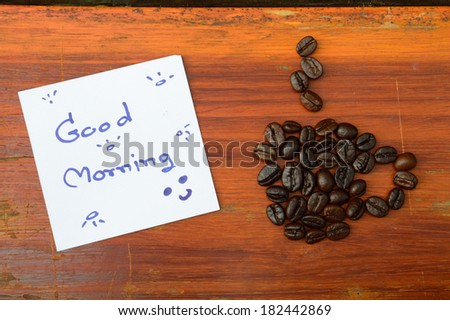 coffee beans and good morning note on the wooden background